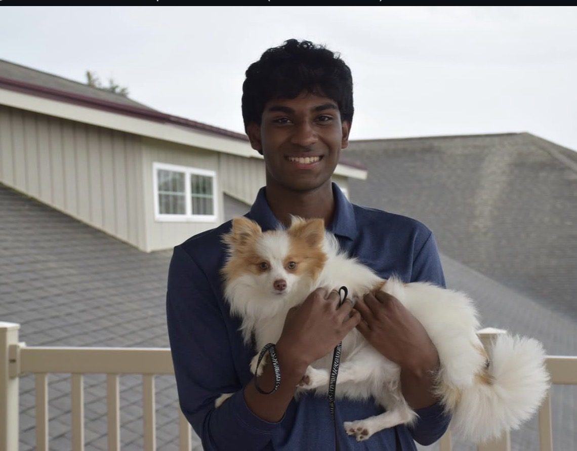 A PAWS FOR A CAUSE volunteer holding a small rescue dog from a partner organization